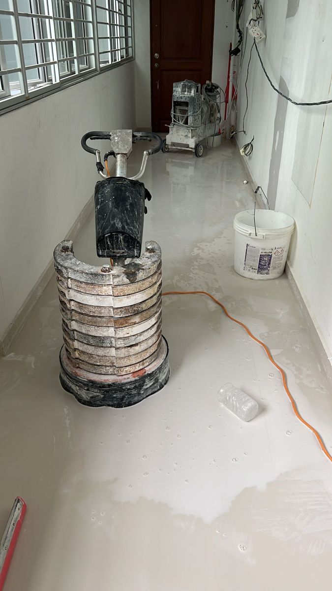 Floor grinding machine applying marble gum on homogeneous tiles in HDB corridor
