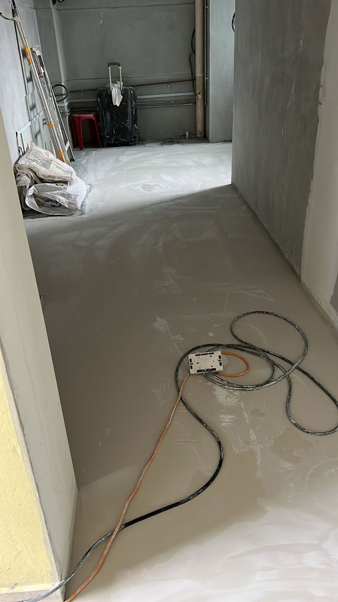 Marble gum applied across homogeneous tiles in HDB living room before grinding